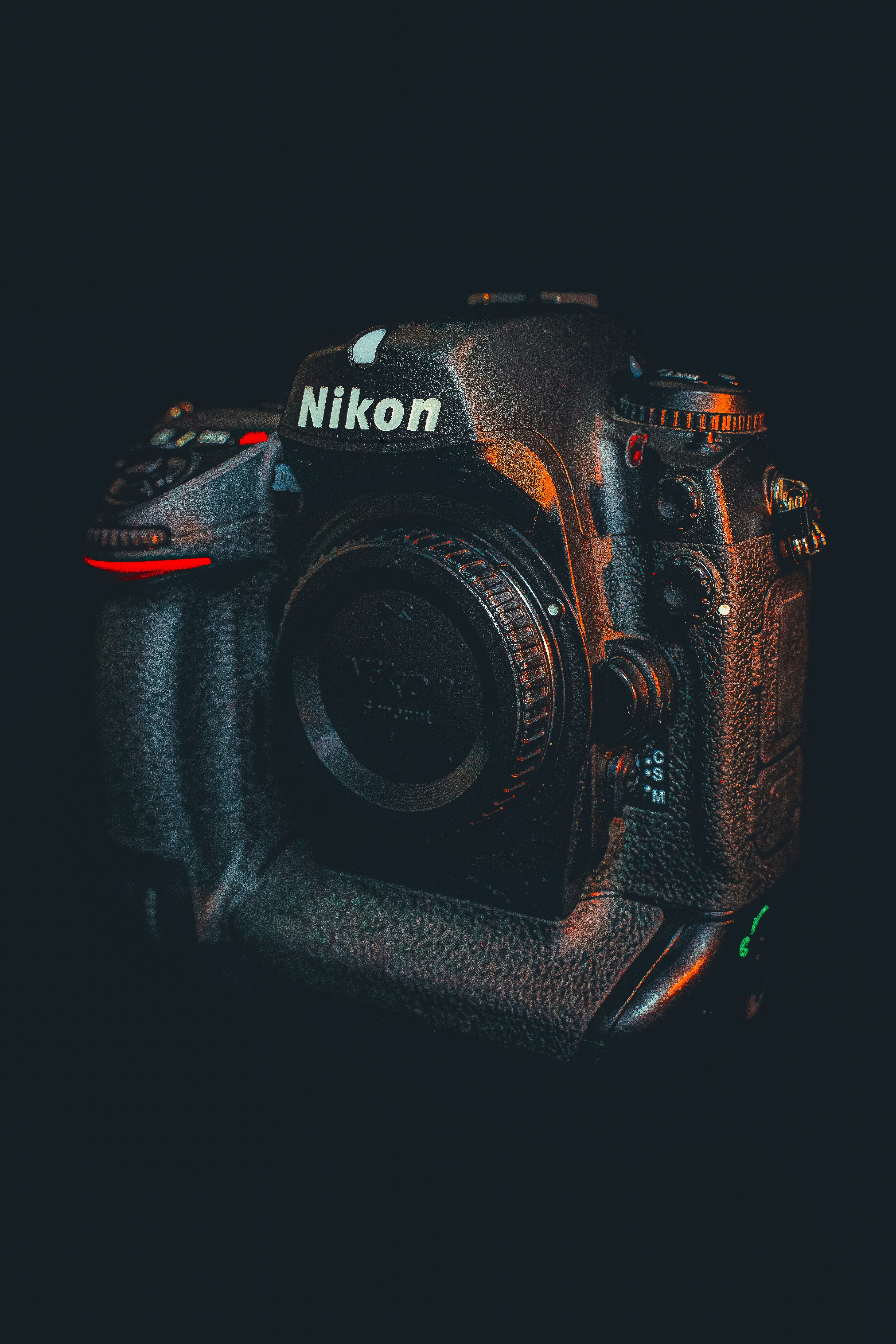 black nikon dslr camera on black surface